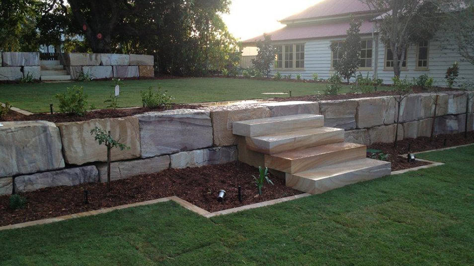 Queensland sandstone retaining wall in landscaped outdoor area